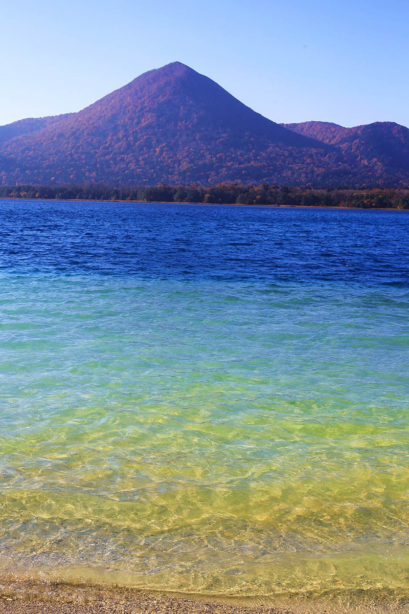 恐山宇曽利湖/青森県北部、下北半島の中央部に位置する恐山のカルデラ湖である「宇曽利(うそり)湖」。火山性ガスが溶け込んだ湖水は酸性値が高いため、棲息する生物はごくわずか。だが、この火山性ガス、硫黄泉の影響によって、この世のものとは思えぬ不思議な色へと湖水を染めていく。(写真提供/TK.NINE)