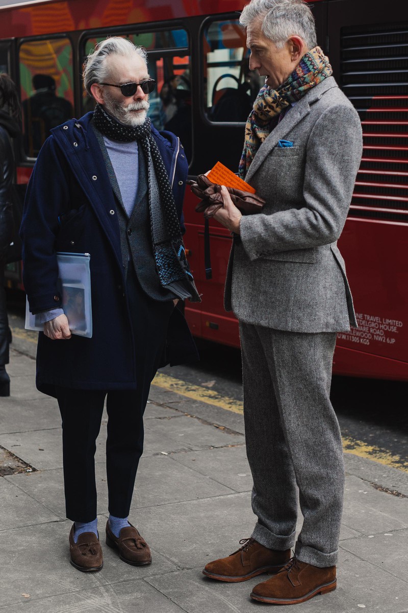 年齢を重ねると派手な色が似合うといいますが、その実例ともいえるのがこんなおふたり。右側の方はグレーのヘリンボーンのスーツをスエード靴と合わせてオーセンティックに。その首元に配された色鮮やかなマフラーがフレッシュな印象です。