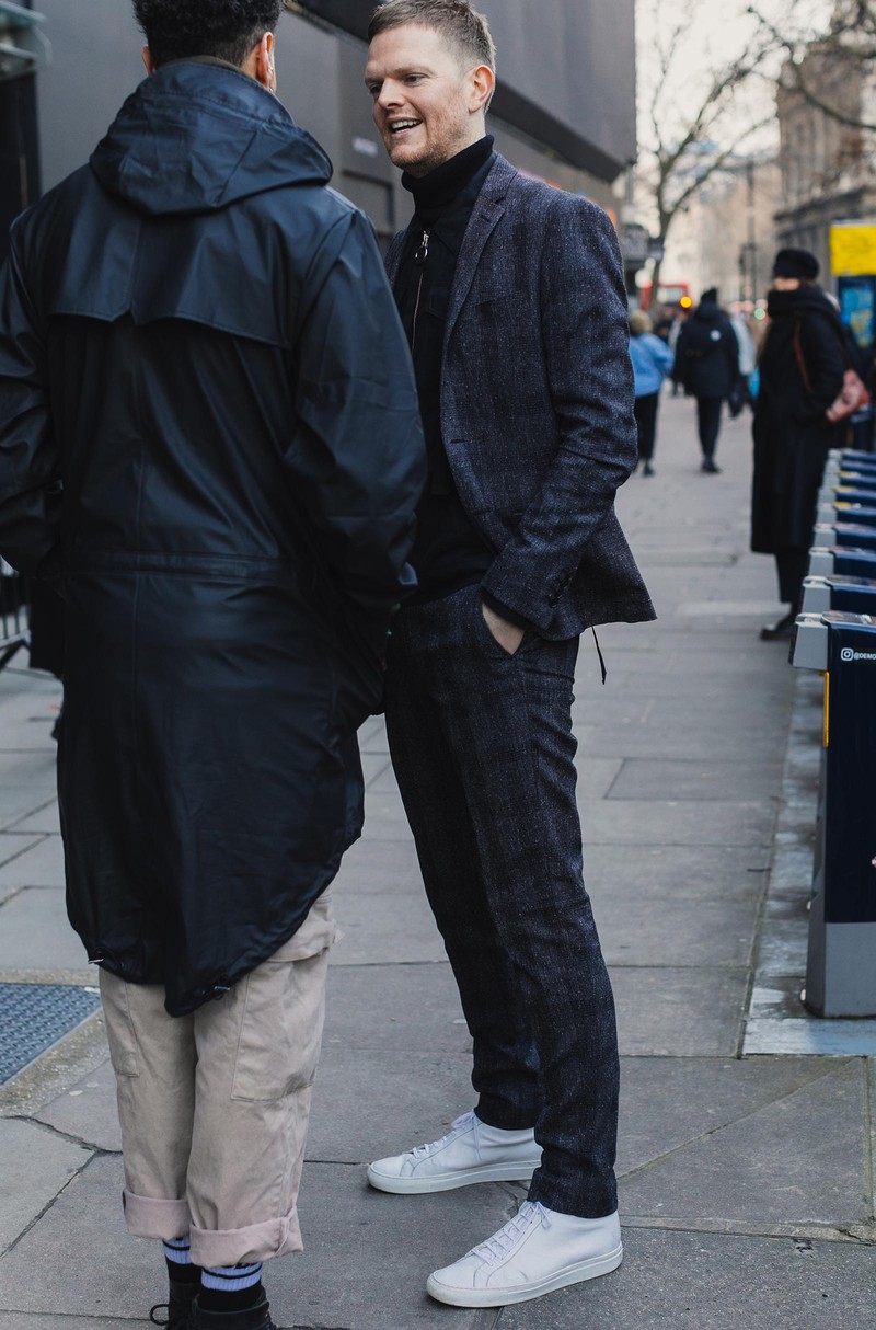 ネップ調のグレンチェックのスーツをスポーティに着流した方。インナーは黒のタートルネックとダークな色調で全身をまとめています。そんなスタイリングがスッキリ見えるのは、白スニの効能。コモンプロジェクツのハイカットスニーカーが足元を引き締めます。