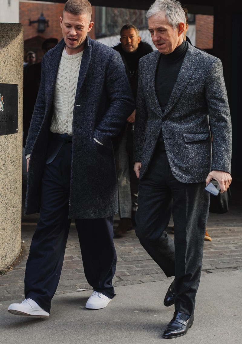 ざっくりと編んだ白いケーブルニットは、冬の定番アイテムですが、どう着たらいまどきに見えるのか? その回答のひとつが左側の方。ネイビーのチェスターコートに、ネイビーのウールパンツ、足元はニットと同じ白スニでスッキリ見せています。ニットの白を活かして色数を抑えているのがポイント。