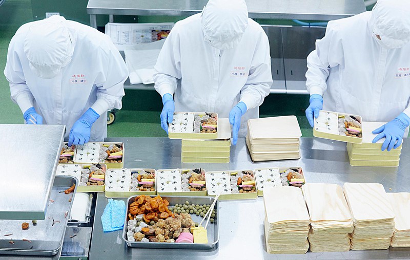 シウマイ弁当は1ラインに30人ほどが列となり、ごはんやおかずを順に詰めていきます。