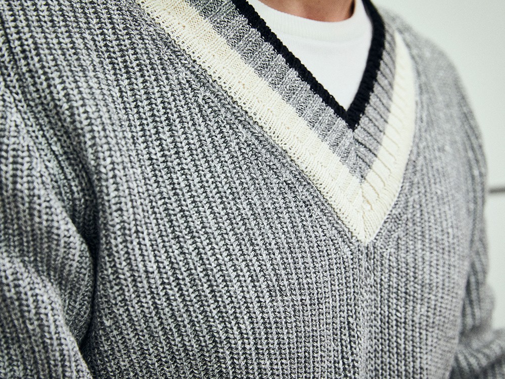 セーターの素材はコットンリネン。ミドルゲージの編み目も加わり平板ではなく豊かな素材感を感じさせるポイントとなっています。また、インに着込んだシャツは普通のＴシャツではなくニットＴ。こういったところも高級感を損なわない気遣いです。