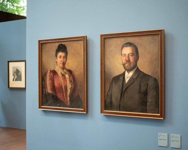 ▲ ドイツ出身の作家・ハンス＝ペーター・フェルドマン（1941〜2023年）の「無題」（2点とも同題）。一見、上流階級の夫婦を描いた肖像画に思えるものの、二人にはピエロのような付け鼻が……。この鼻が付くだけで、厳かなはずだった肖像画が剽軽な印象へと変わります。ですが、彼らが実在する人物だったとしたら、厳かな人だったのでしょうか、剽軽な人だったのでしょうか。私たちは顔からついつい、どんな人かを勝手に想像してしまいますね。