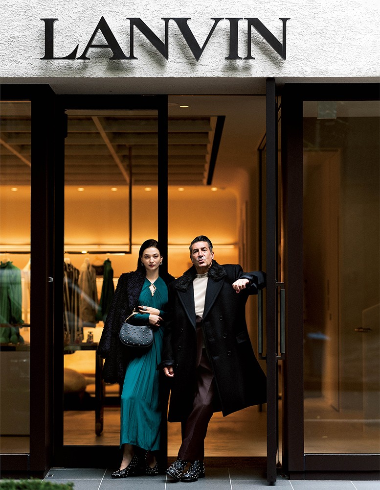 ▲ 男性●コート62万7000円、ジャケット47万800円、パンツ19万4700円、ニット25万4100円、ブーツ34万6500円/すべてランバン(ランバン銀座店) 女性●コート70万6200円、ワンピース37万1800円、イヤリング16万1700円、リング11万3300円、パンプス20万7900円、バッグ51万8100円/すべてランバン(ランバン銀座店)