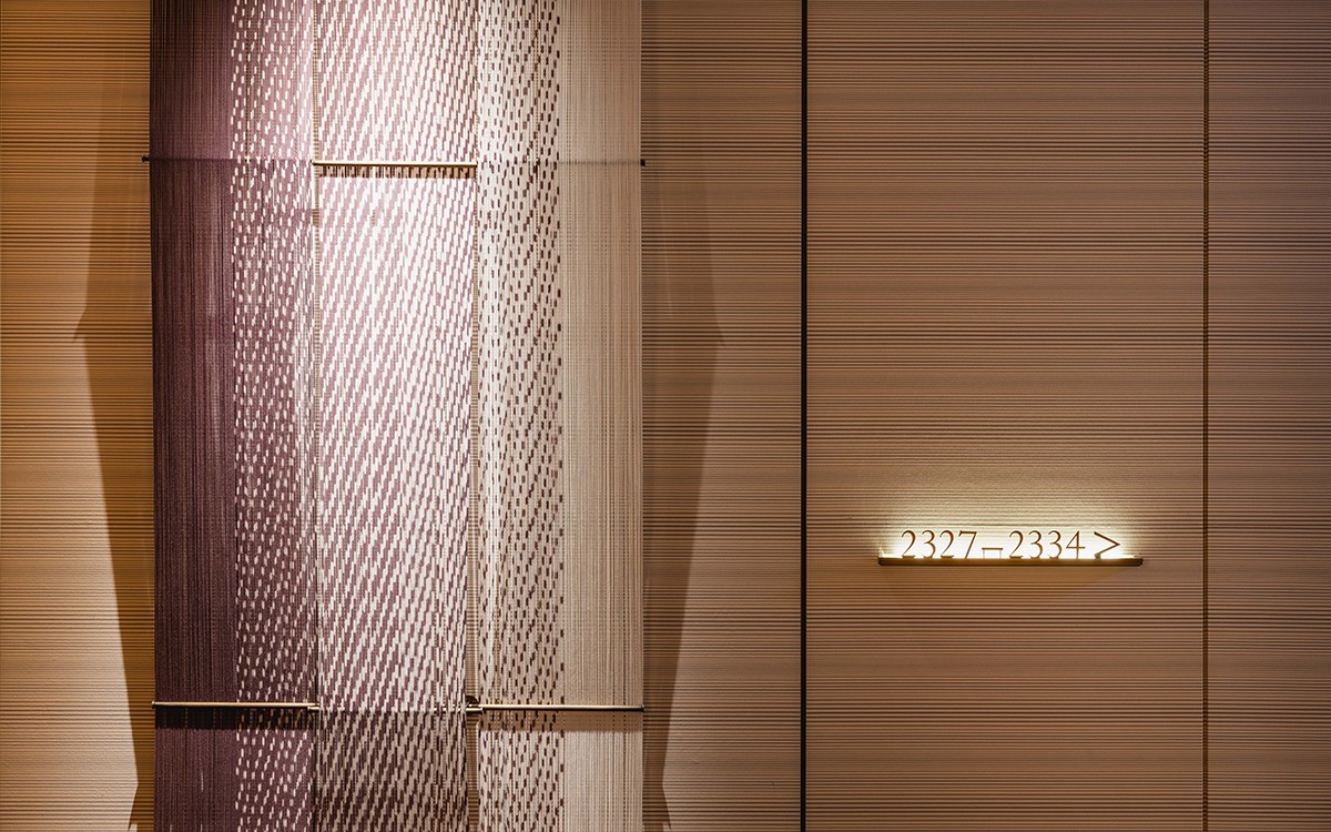 ザ・リッツ・カールトン福岡 小倉縞縞や久留米絣など福岡の織物をテーマにした作品が並ぶ客室前の廊下。