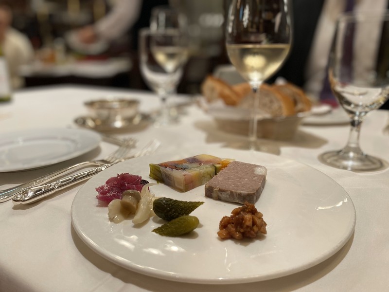帝国ホテル LEON.JP 豚肉のパテ・ド・カンパーニュ(奥右)などから5種類から選べるテリーヌ。奥左は女性連れならマストでオーダーしたい野菜のテリーヌ。ブロッコリー、ヤングコーン、ニンジン、キャベツなどを、ブイヨンのゼリーと共にあしらっている。付け合わせ(手前)の赤キャベツのマリネやピクルスなどもいちいち旨し(笑)。