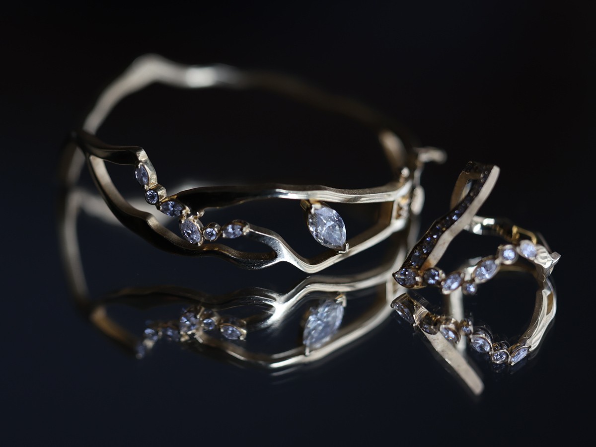 稲木氏のパーソナルピースであるKINTSUGIバングルと、KINTSUGIヴィクトリアフロートパヴェダイヤモンドリング。金継ぎを思わせる18金イエローゴールドのラインにダイヤモンドをあしらった特別なアイテムだ。