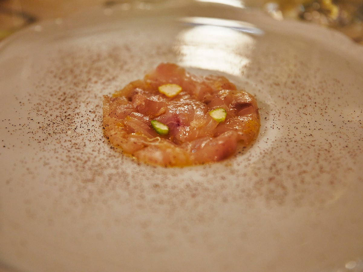 サーモンのカルパッチョ。酸味の効いたソースとピスタチオの触感が美味しい前菜。