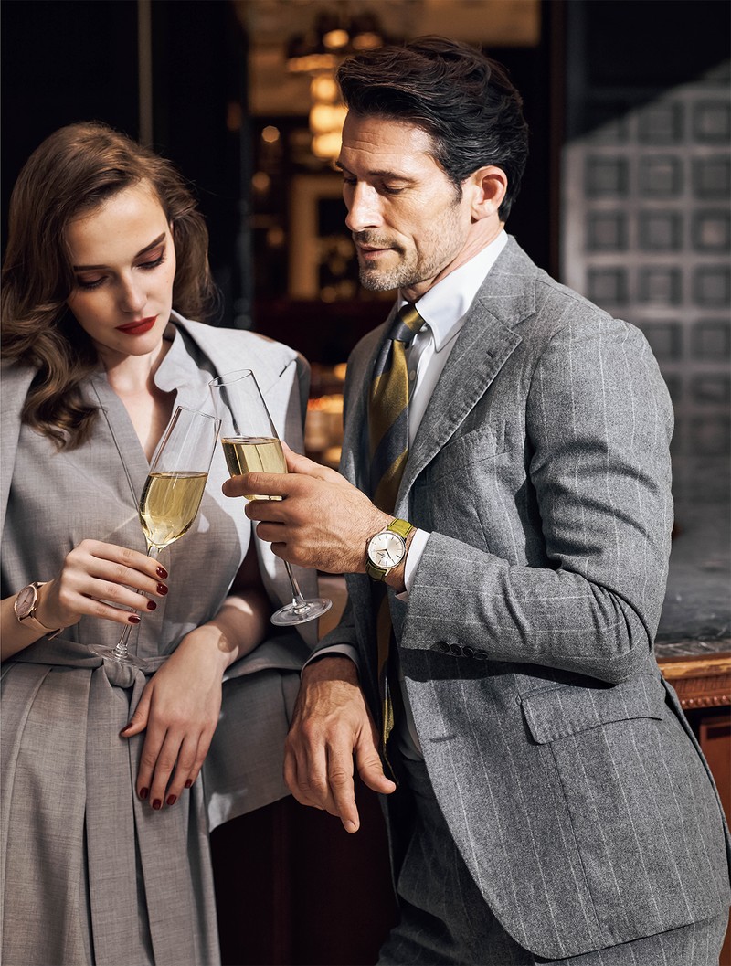 ▲ ライトグレースーツで腕元とトーンを揃えるのが◎ この淡色のパトリモニーをより洒脱に見せたいのなら、ライトグレーのような淡い色味のワードローブとコーディネートするのがベストです。時計とスーツが淡いトーンが揃うことで、モダンな色気を醸し出します。男性●時計374万円/ヴァシュロン・コンスタンタン、スーツ20万9000円/ティト アレグレット、シャツ2万900円/ビームスF(ともにビームス 六本木ヒルズ)、タイ3万3000円/ブライスランズ×セブンフォールド(ブライスランズ&コー) 女性●時計545万6000円/ヴァシュロン・コンスタンタン、ジャケット17万4900円、ワンピース15万2900円/ともにイレブンティ(三喜商事)