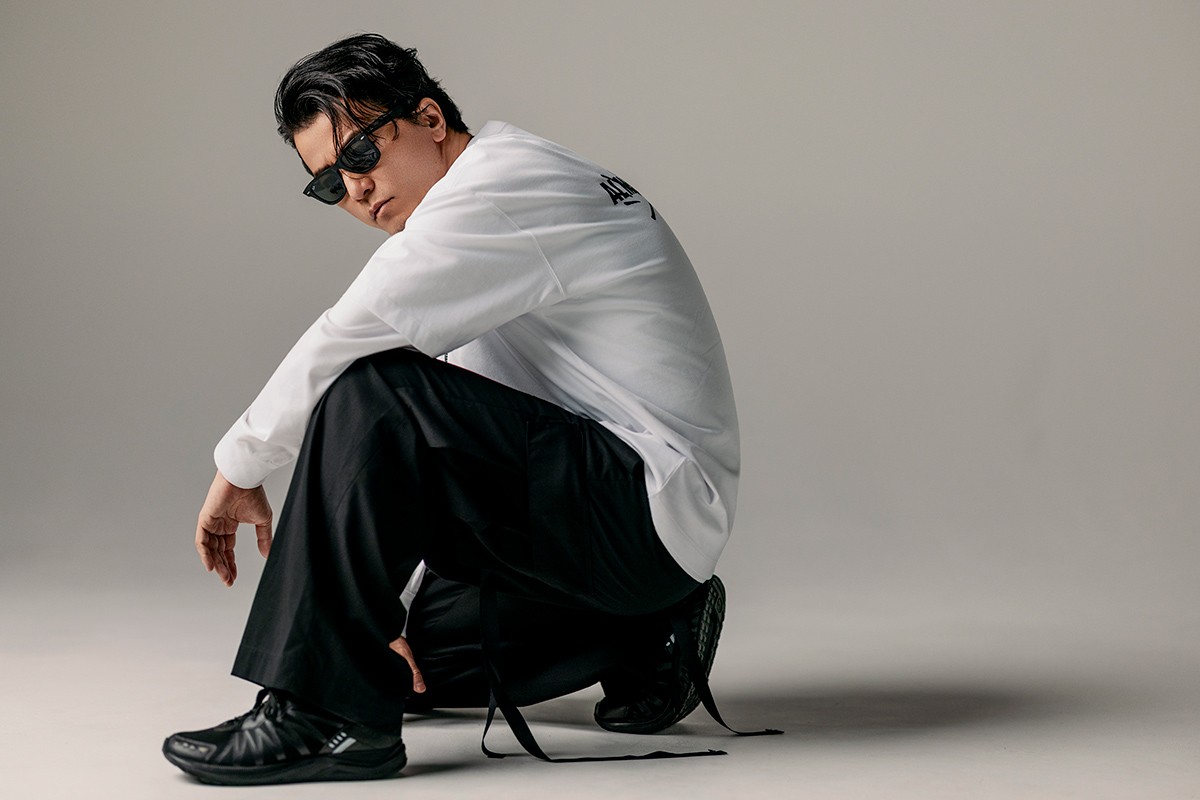 ALMOSTBLACK初となるロゴTシャツが誕生。KREVAのサインを重ね、流れるリリックのように。哲学を背中に刻んで。Tシャツ1万9800円、重ねたロングスリーブTシャツ2万2000円、ドッグタグ6798円(*6/21より受注開始予定)、ブローチ付きバケットハット1万6500円/KREVA×ALMOSTBLACK、パンツ6万3800円/ALMOSTBLACK、サングラス、シューズ/私物