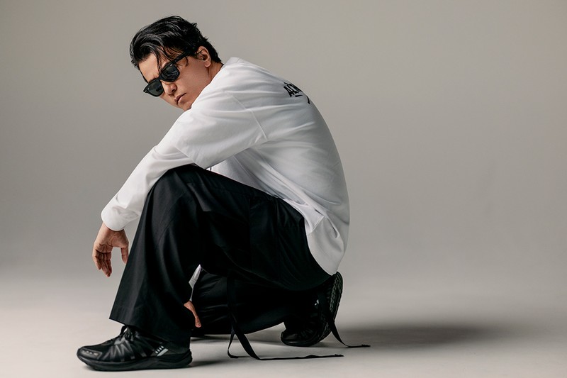 ALMOSTBLACK初となるロゴTシャツが誕生。KREVAのサインを重ね、流れるリリックのように。哲学を背中に刻んで。Tシャツ1万9800円、重ねたロングスリーブTシャツ2万2000円、ドッグタグ6798円(*6/21より受注開始予定)、ブローチ付きバケットハット1万6500円/KREVA×ALMOSTBLACK、パンツ6万3800円/ALMOSTBLACK、サングラス、シューズ/私物