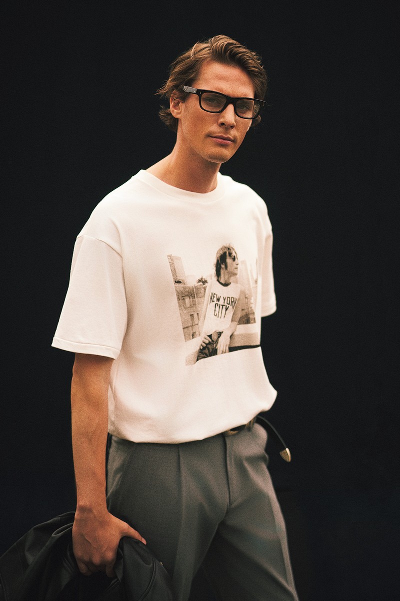 Tシャツ1万8700円／バーニーズ　ニューヨーク、手に持ったブルゾン12万1000円／アルマ（ノウン）、パンツ9万3500円／イレブンティ（三喜商事）、メガネ5万380円／オリバーピープルズ（ルックスオティカジャパン カスタマーサービス）、ベルト3万800円／アルベルト ルティ（アマン）