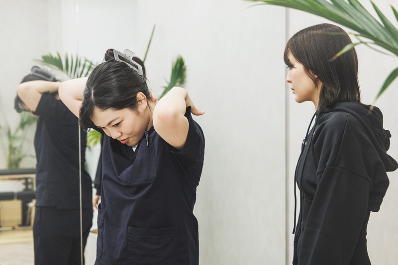 「鍼灸接骨院」の施術が終わり、鍼灸師の橋本さんからピラティスのインストラクターMIOさんへ渡辺の状態や気になるポイントを申し送り。ふたりの間でしっかり連携をとることで、渡辺の悩みや症状に両面からアプローチするのが新鮮！ まさにノムラボの真髄です