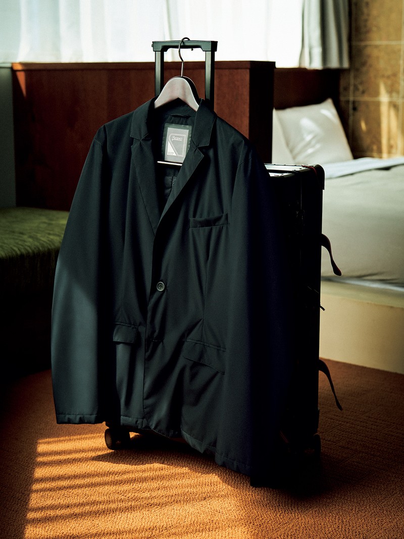 ジャケット12万9800円／ヘルノ（ヘルノ・ジャパン）、スーツケース57万2000円／グローブ・トロッター（グローブ・トロッター銀座）