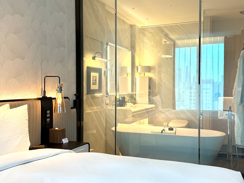 ベッドの隣に鎮座するバスタブ。仕切りはスモークをかけることも可。