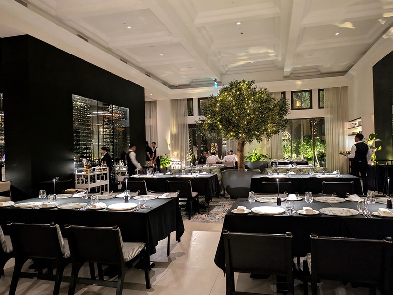 ちょっと隠れ家的なドアの向こうには広々とした空間が広がる。真ん中のワインセラーではワインのテイスティングなどのイベントを開催することも