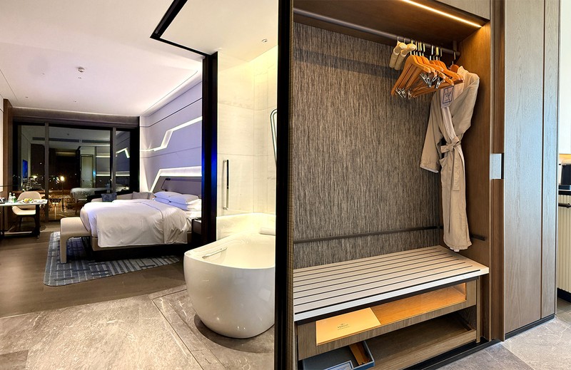 左●バスタブが客室中央に鎮座しますが、戸を引けば壁を作れます。右●クローゼットには綺麗なバスローブも用意。