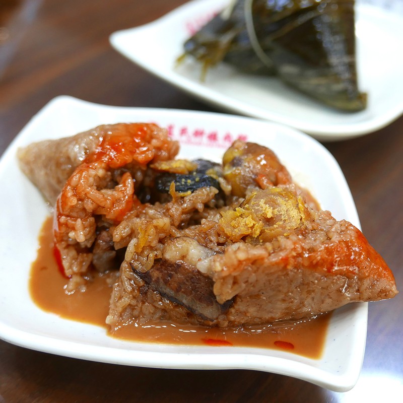 粽の中は干し海老、豚バラ肉、栗、椎茸、卵黄、ソーセージと具沢山で、まるで米の宝箱。ピーナッツソースと甜辣酱醤でいただきます。米には地元の小粒なうるち米が使われ、その米の味もよき。1個約330円